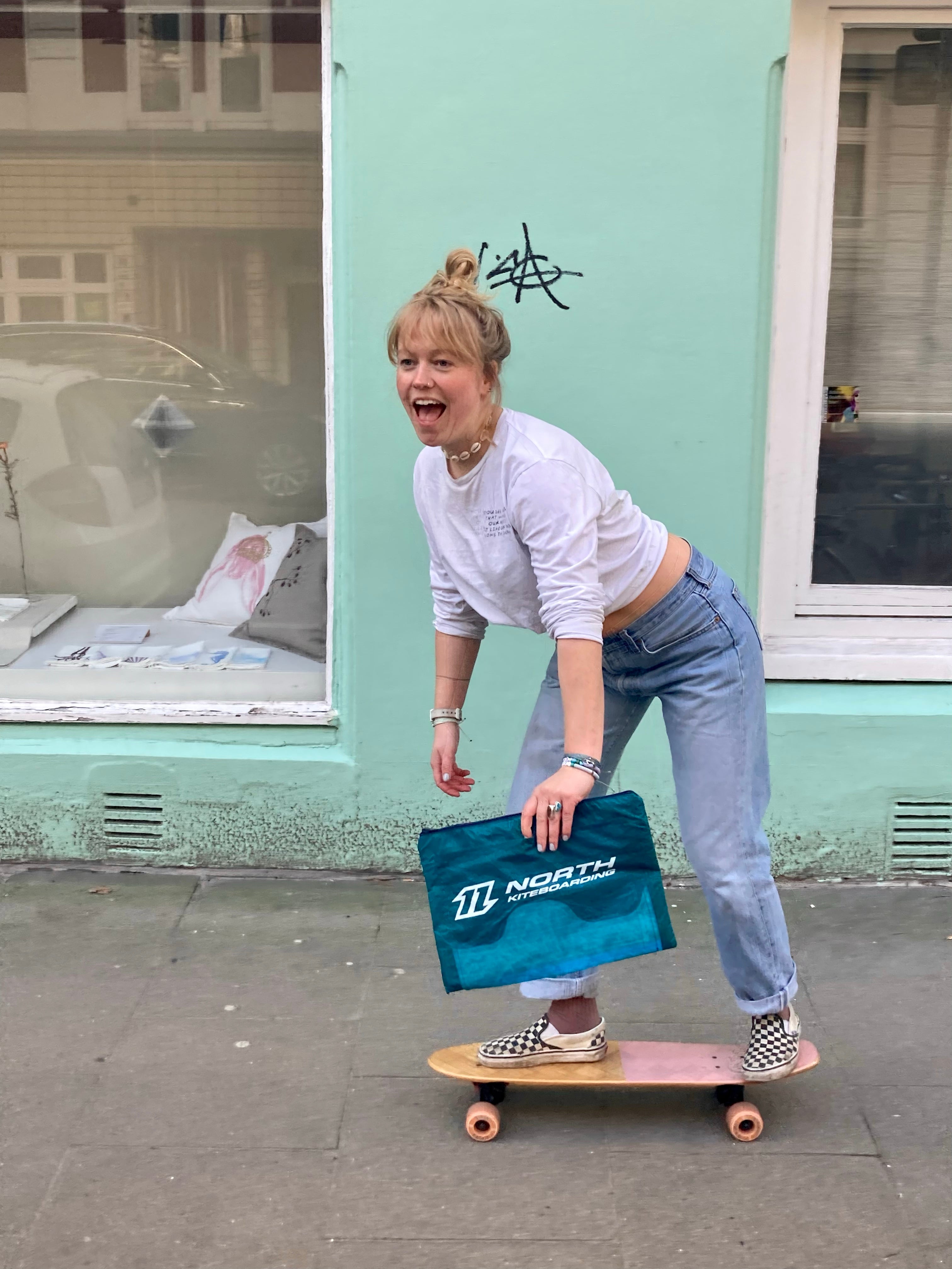 Skatende Frau mit Upcycling Tasche aus recyceltem Kite-Material – nachhaltige Handtasche
