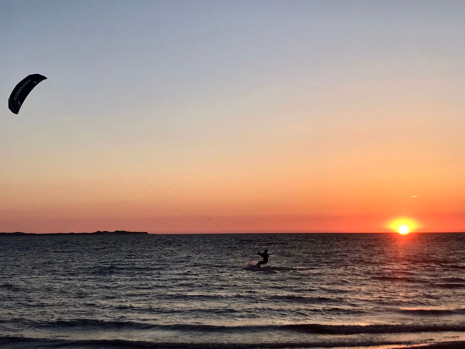 Kitesurferin beim Sonnenuntergang
